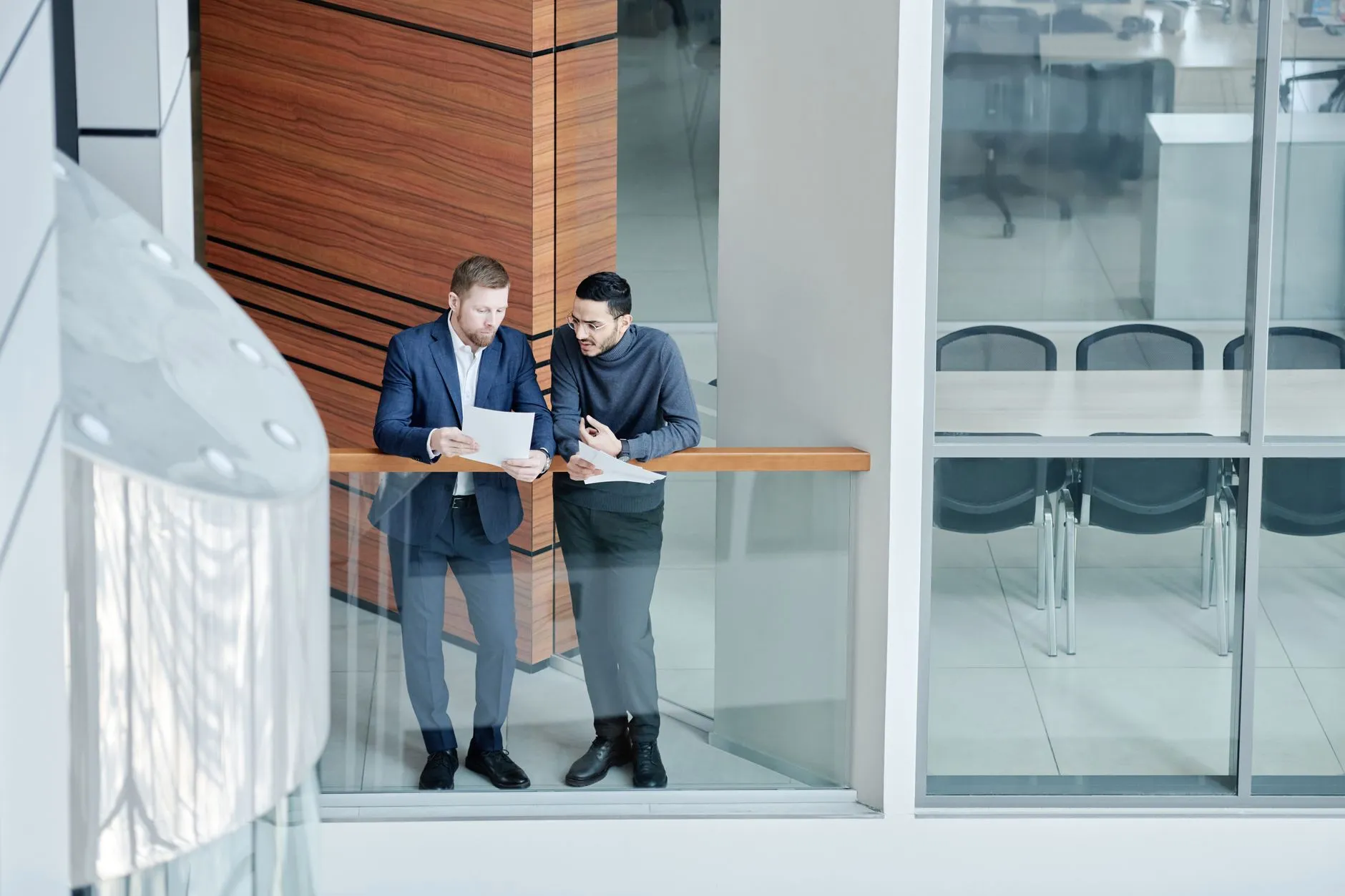 Two professionals reviewing documents together in a modern office