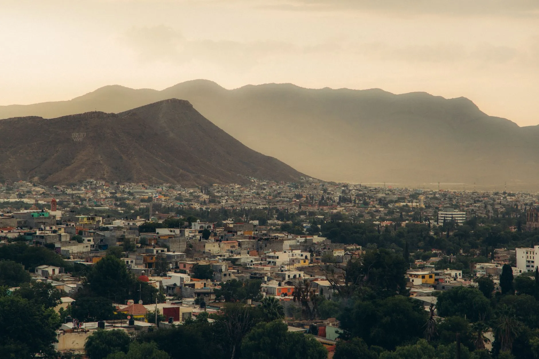 A city spread out beneath a mountain range at dusk
